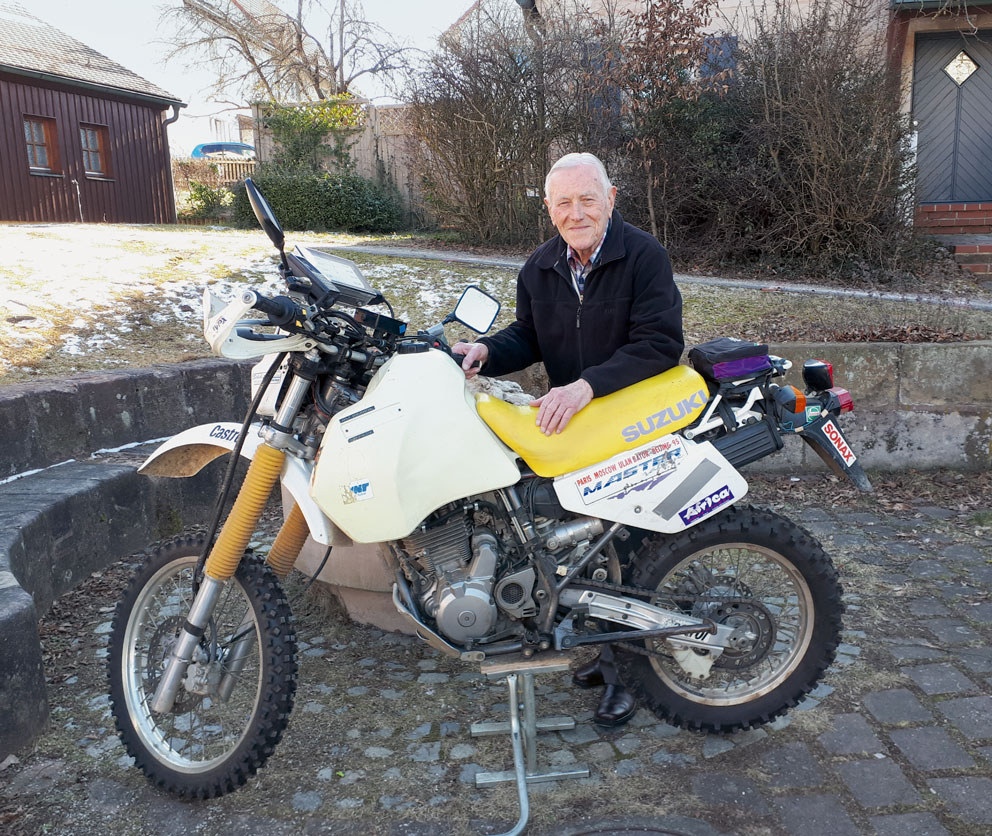 Herr Scheuenstuhl hinter Motorrad stehend.